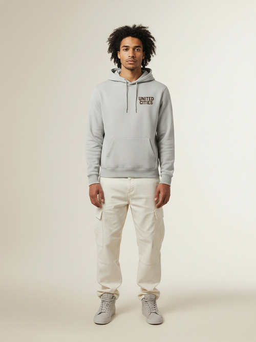 UNITED CITIES / ANTWERP Heavy Hoodie – Licht asfalt met donkerbruine, matte belettering. 65% katoen, 35% polyester, geborsteld fleece (300 g/m²). Ruime pasvorm.